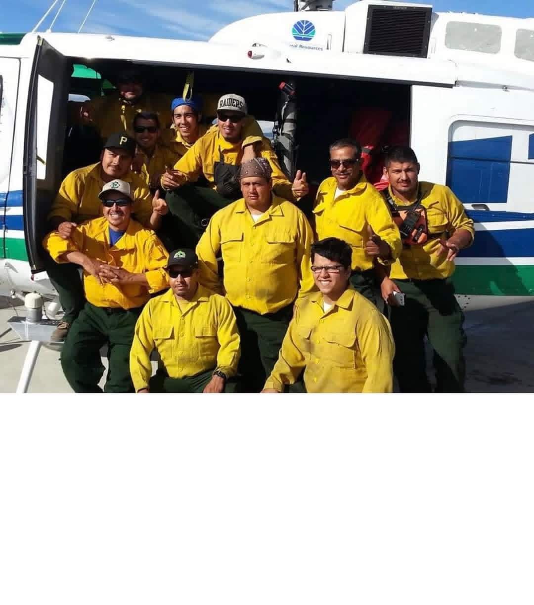Wildfire hand crew posing at the helicopter