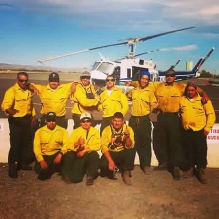 Crew portrait in front of a Bell helicopter