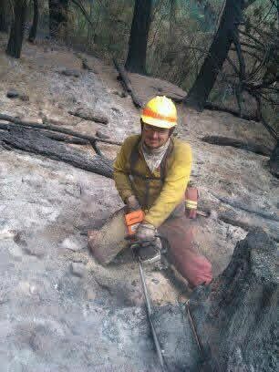 Firefighter mopping up hot spots after the burn